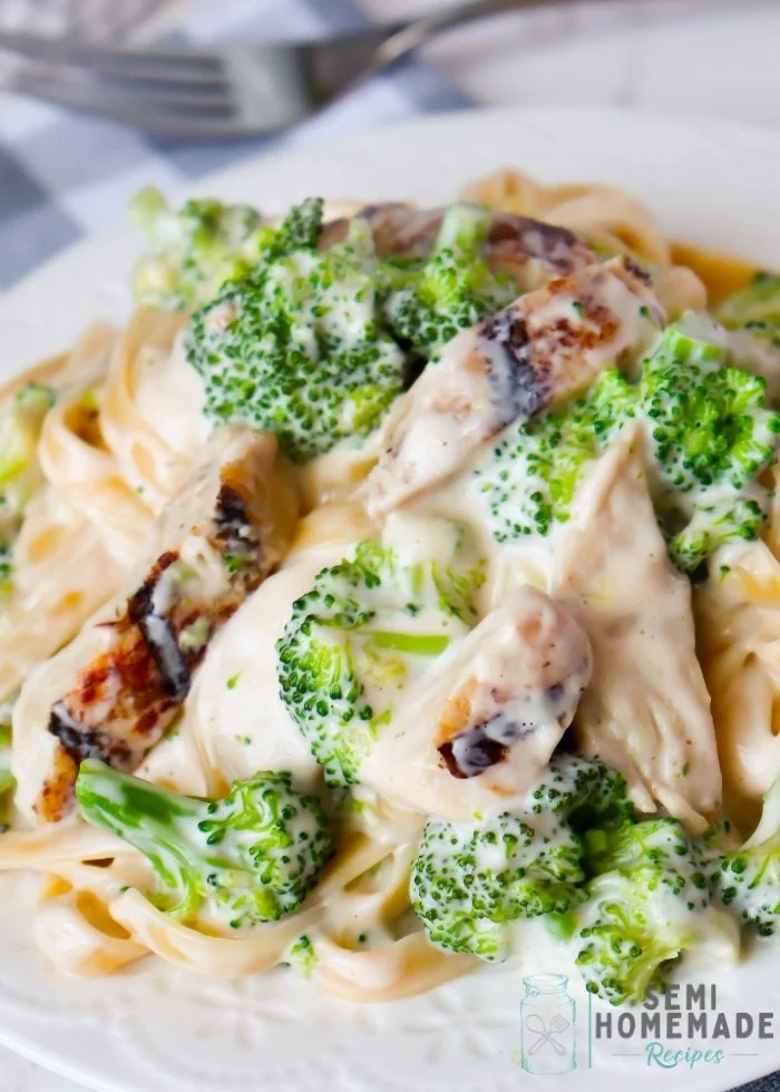 Creamy Chicken Broccoli Alfredo Fettuccine in a bowl topped with fresh parsley.