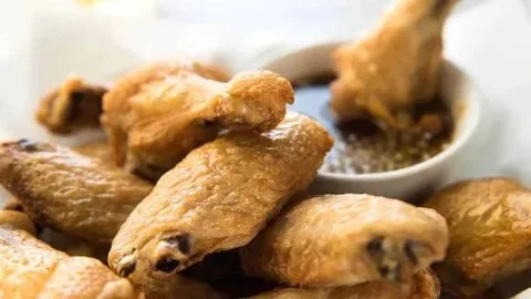 Crispy oven baked wings served on a plate with dipping sauce