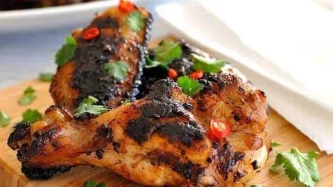 Crispy Vietnamese chicken wings served with dipping sauce on a white plate.