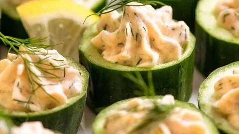 Cucumber bites garnished with smoked salmon mousse for a gourmet appetizer.