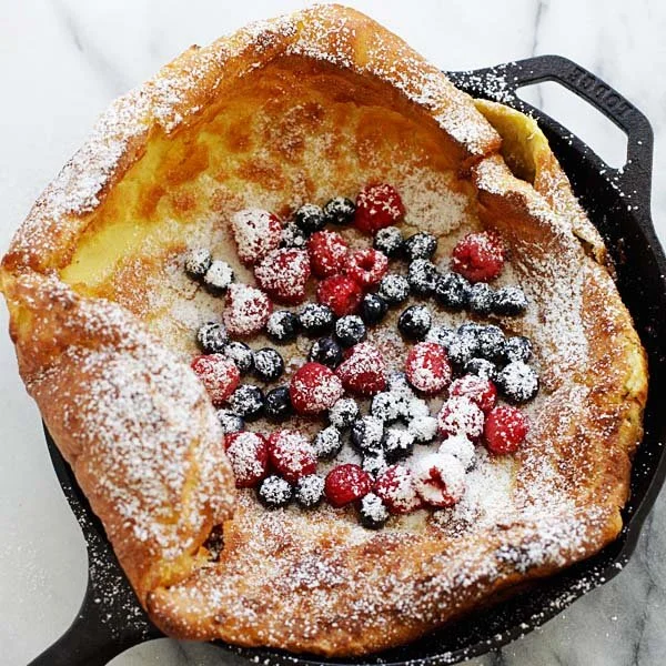 Delicious homemade Dutch Baby pancake with fresh fruit and powdered sugar