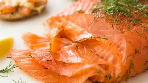 Plate of easy cured salmon gravlax garnished with dill and lemon