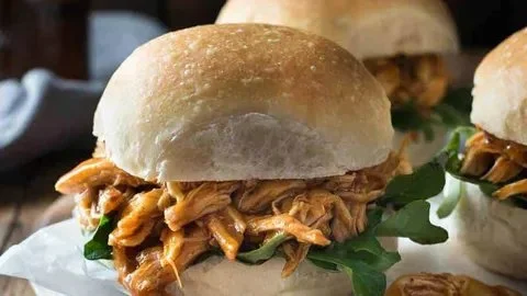 Honey buffalo chicken sliders served with fresh ingredients and dipping sauce.