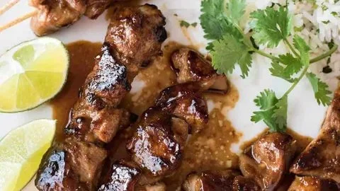 Delicious sticky honey sriracha chicken skewers on a platter